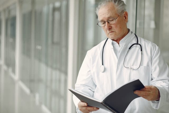 elderly doctor looking at notes