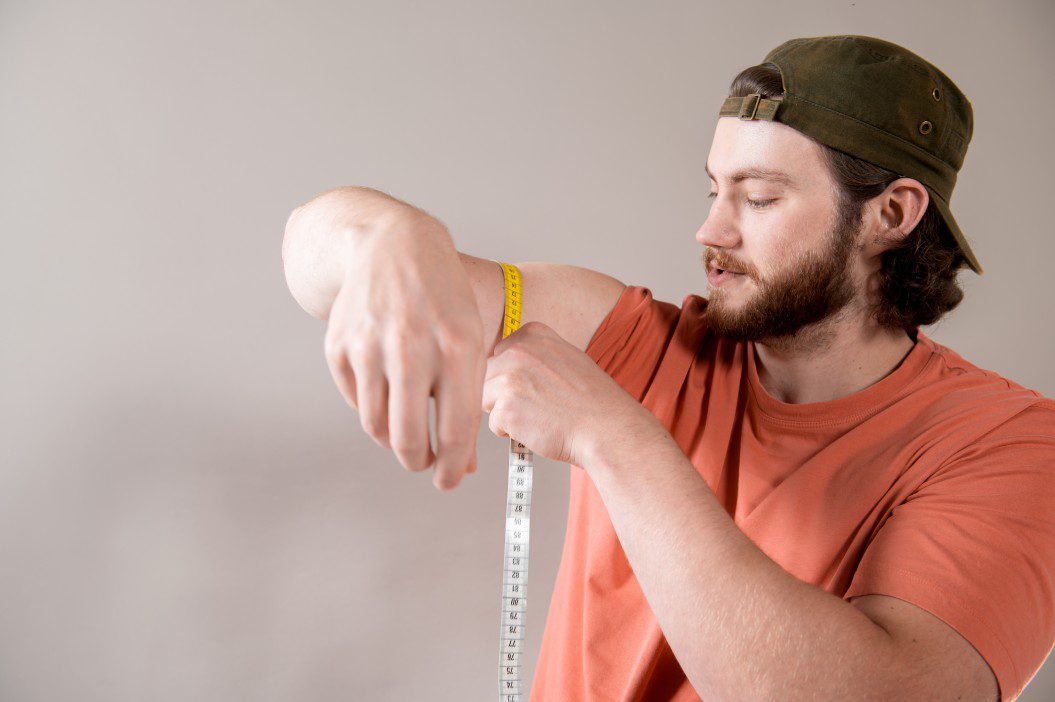 A man measuring his arm for his brace