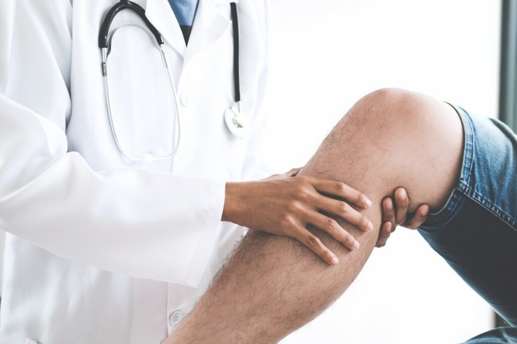 A doctor examining a patients knee pain