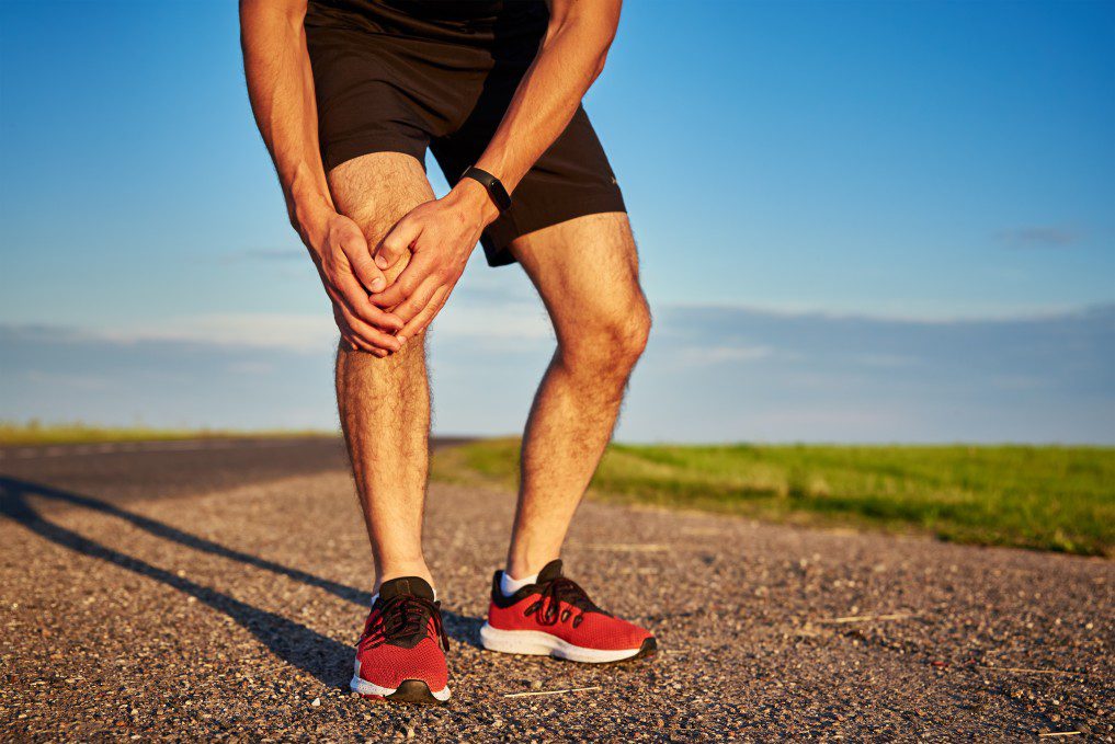 A runner holding his knee after running